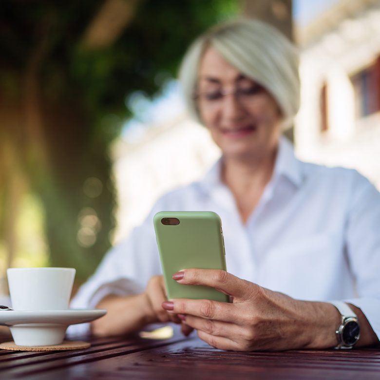 J2653_Mobile-Captions-1200×1200-1-780×780 Senior woman smiling while using a cell phone