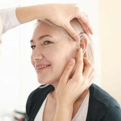 J2496_HA_1200x1200_Update-390×390 Doctor inserting a hearing aid into a senior woman's ear