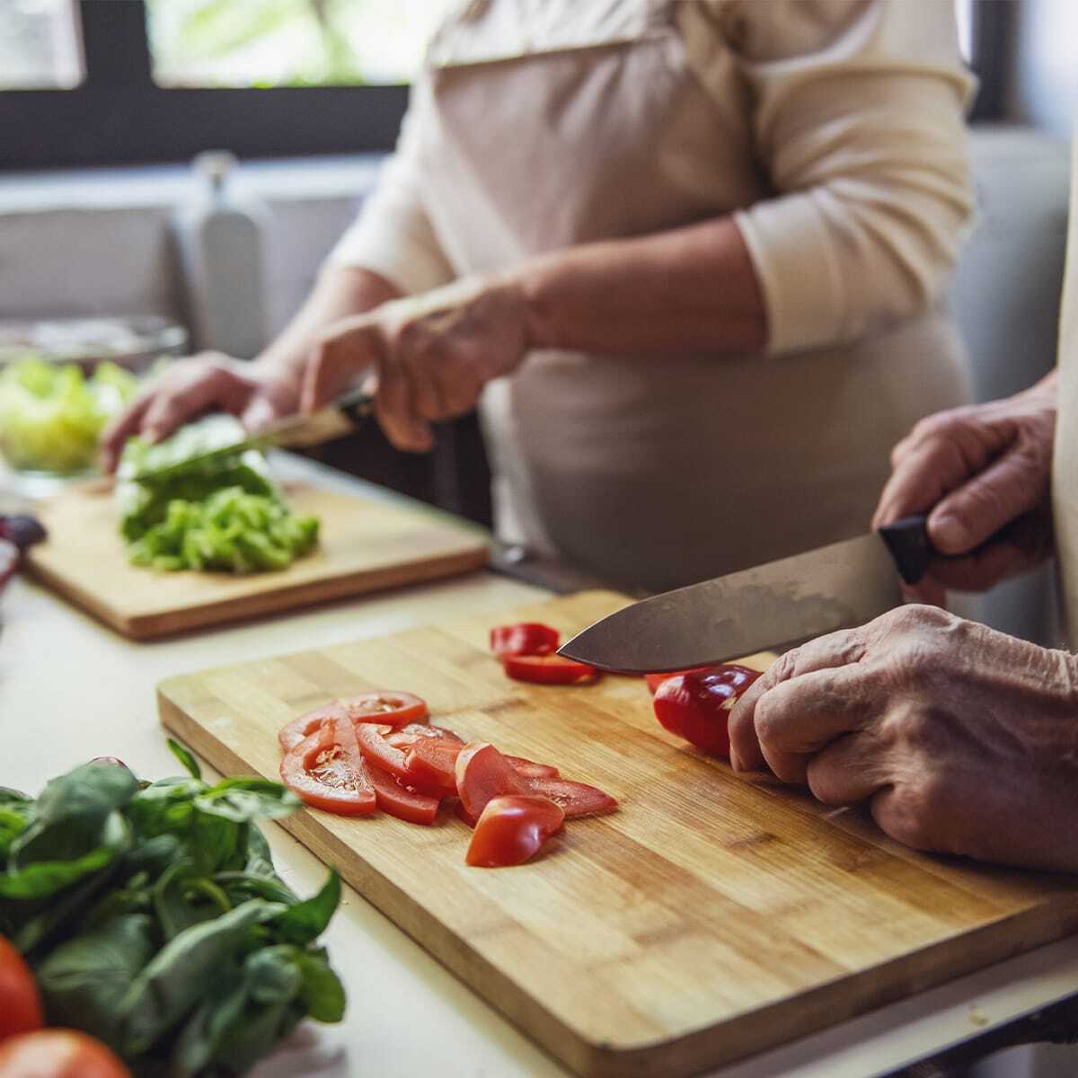 Senior couple cutting vegetables