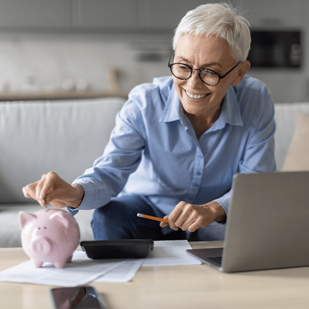 Senior woman inserting a coin into a piggy bank