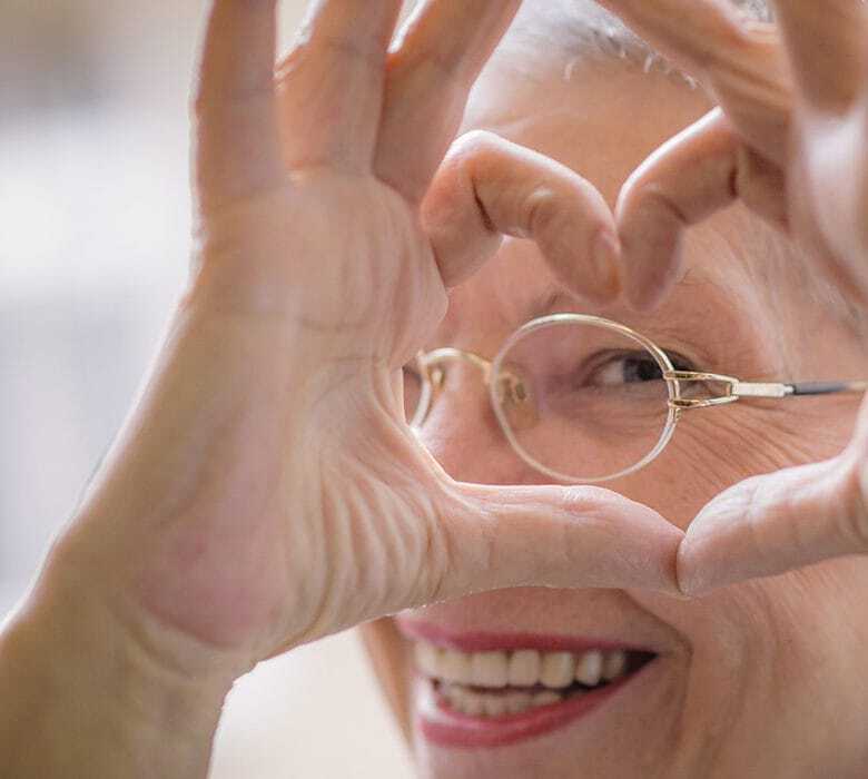 Senior woman making a heart shape with her fingers