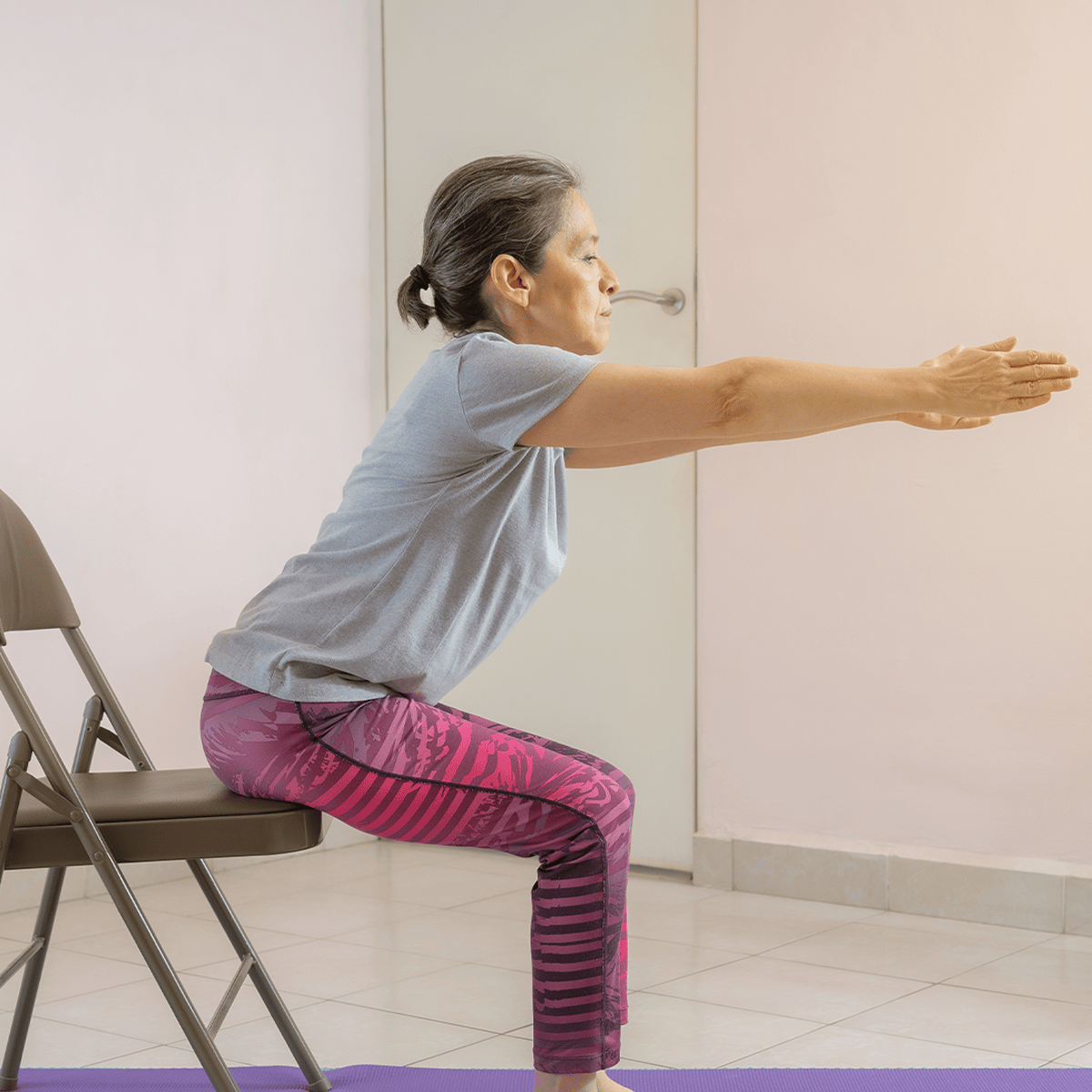 Senior woman performing yoga chair