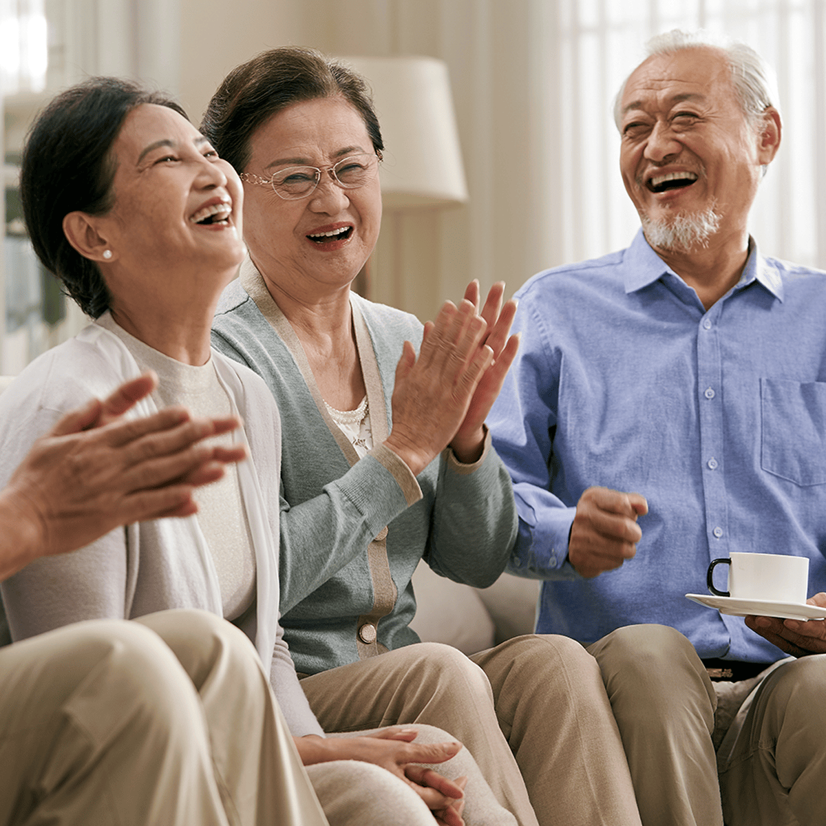 Senior friends laughing and clapping their hands
