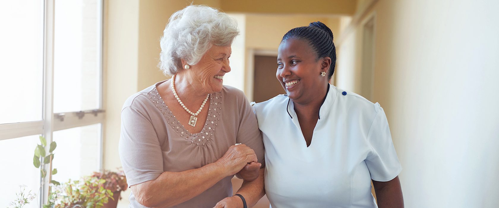 Senior woman and caregiver smiling at each other