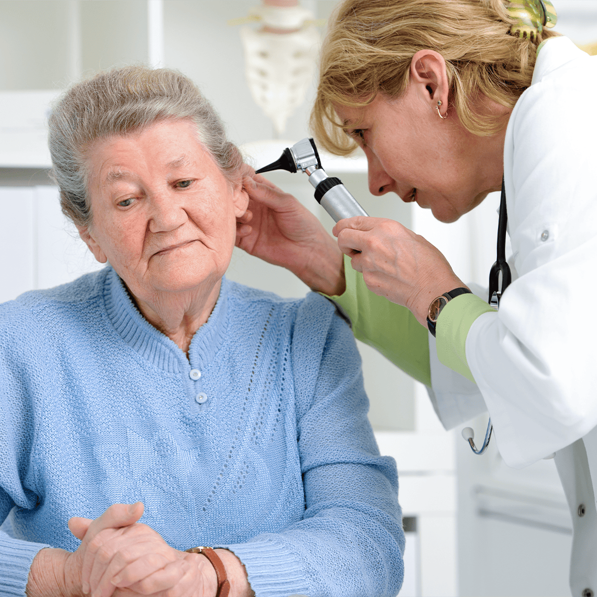 cbeb94fb-2d19-497d-8002-c58a605a6618 Doctor examining a woman's ear with an otoscope