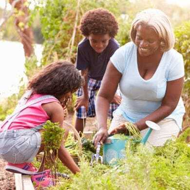 Mother and two children taking care of the garden together