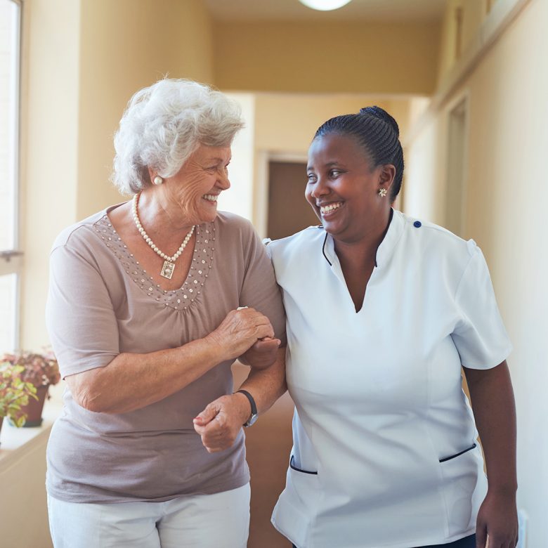 Senior woman and caregiver smiling at each other
