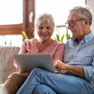 Senior couple smiliing while using a computer