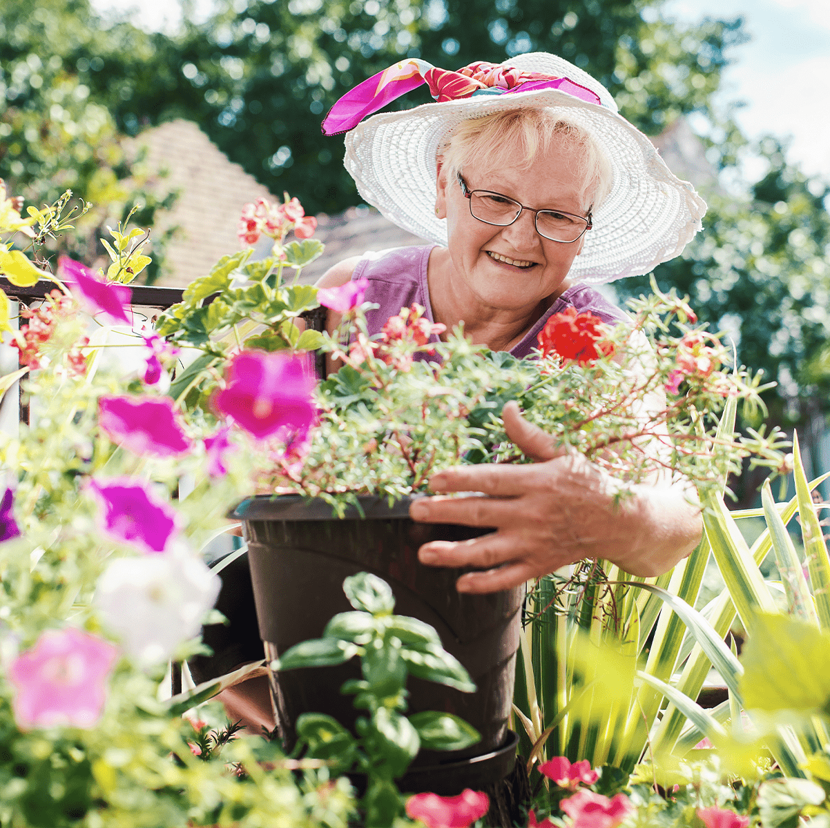 Senior woman smiling while looking at her flowers
