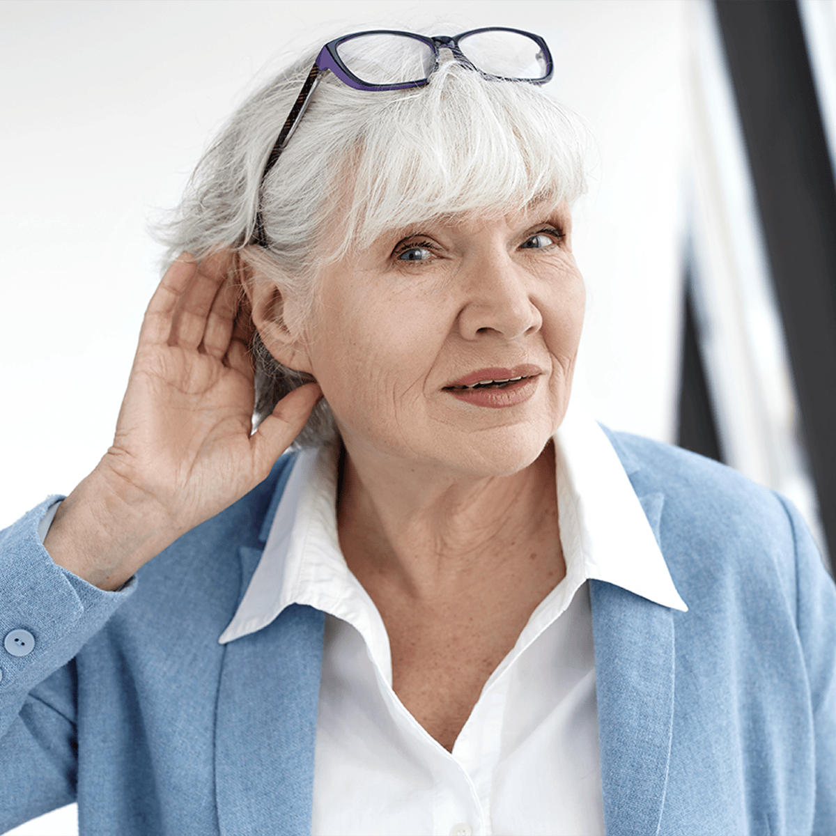 Senior woman cupping her ear to listen better