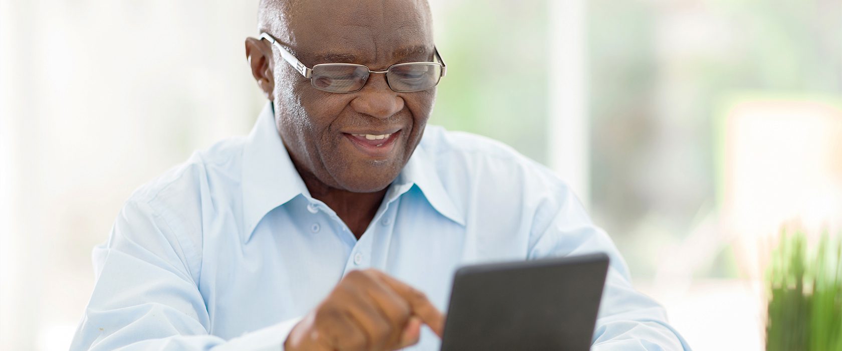 Senior man smiling while using a tablet