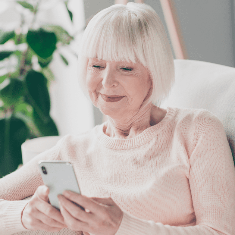 J2668_Blog_Stories-of-Connection_1200x1200-780×780 Senior woman smiling while using a cell phone